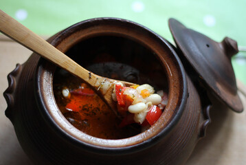 Bean soup in a clay pot, close up 