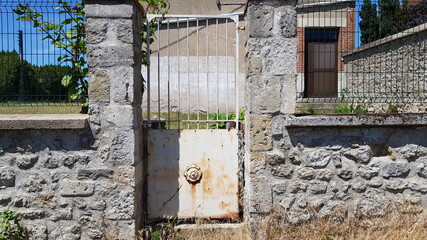 Ancien portillon métallique sur clôture en pierre type muret