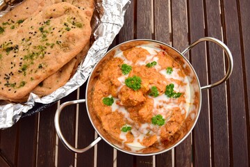 Murgh Makhani or butter chicken served with homemade whole wheat garlic Naan bread