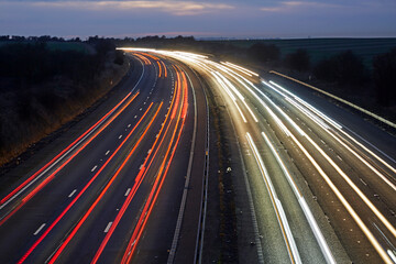 Elevated view of car light trails in the M4 in Swindon, Wiltshire, UK - obrazy, fototapety, plakaty