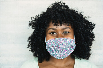 Happy black girl smiling under protective face mask - Young millennial person during coronavirus...