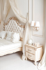 Fototapeta na wymiar Elegant bedside and sconce. Luxury interior in white colors