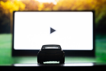 Drive-in theater or drive in cinema, open air movie. Car on the background of a large movie screen,...