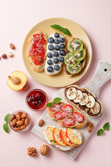 Sweet sandwiches with fruits and berries on pink colorful background.