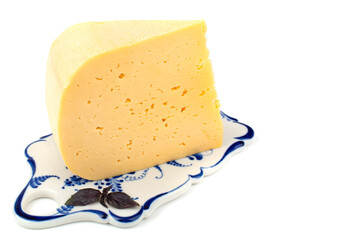 a piece of hard cheese on a ceramic tray, isolated white background, close-up,