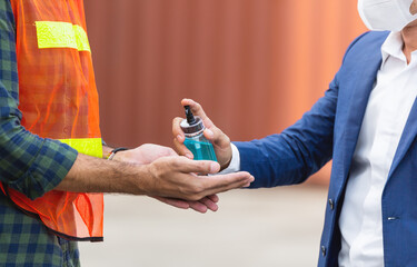 Close up factory worker using alcohol gel or hand sanitizer in construction site. Healthcare and medical concept for industrial manufacturing people