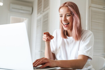 Cheerful young girl using laptop computer