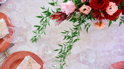served table with plates ant glasses decorated by flowers
