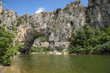 Fototapeta na wymiar Panorama du Pont d'Arc et de la rivière Ardèche sur laquelle évoluent des canoës