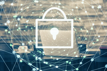 Double exposure of desktop with computer and lock icon hologram. Concept of data safety.