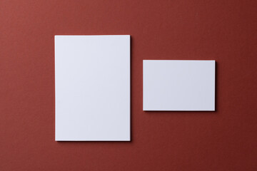 Fototapeta premium Blank white business cards on burgundy paper background