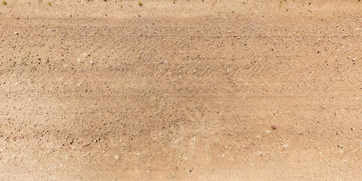 view from above on texture of gravel road with car tire tracks