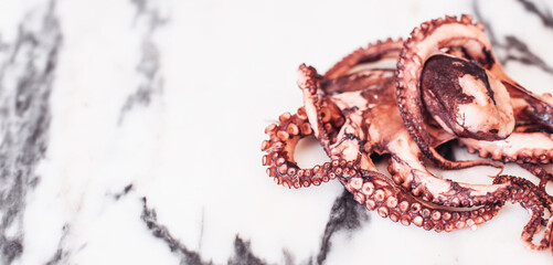 Naklejka premium Close up picture of an octopus on a marble table. White space for design or text