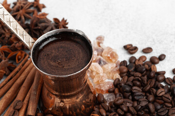 Close up of copper coffee turk on light textured surface