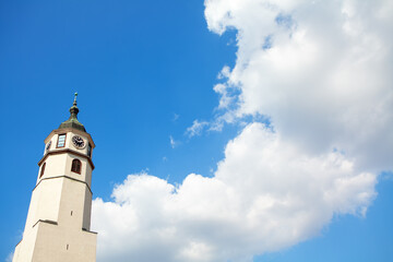 Fototapeta na wymiar belfry with christian cross and clouds on blue sky 