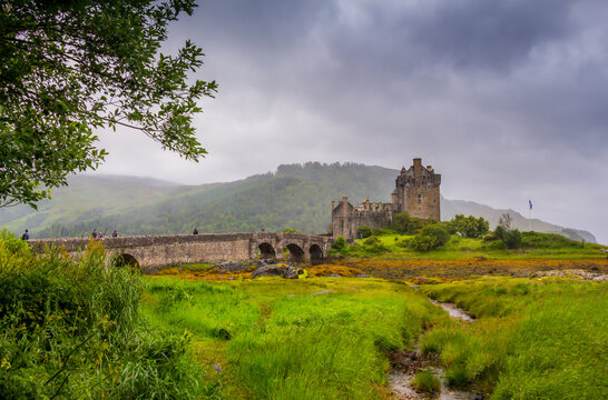 Looking out to Eilean Donan Castle, where three sea lochs meet, Loch Duich, Loch Long and Loch Alsh, on an overcast day in the Scottish highlands.