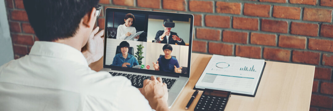 Asian Man Working From Home Use Smart Working And Video Conference Online Meeting With Asian Team Using Laptop And Tablet Online In Video Call For New Projects