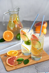Infused detox water with grapefruit, orange, lemon and lime and ice in glasses 