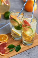 Infused detox water with grapefruit, orange, lemon and lime and ice in glasses 