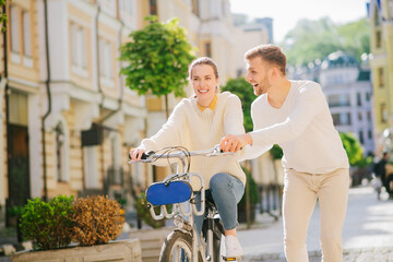 Contented woman riding a bicycle and joyful man