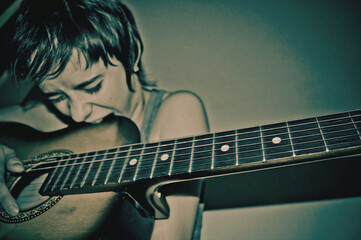 a musician girl bites the body of a guitar