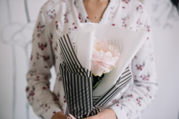 Very nice young woman holding beautiful mono bouquet of fresh single mother choice Peony, cropped...