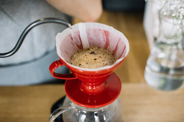 Young woman brewing pour over coffee, top view