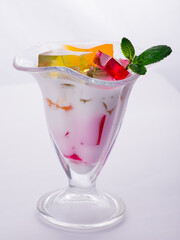 milk fruit dessert souffle mousse with pieces of jelly in a beautiful glass on a leg on a white background
colored jelly