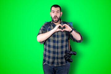 Portrait of happy handsome traveler man making heart with fingers