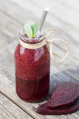 healthy detox beet smoothie in jar on wood background