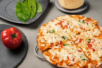 Vegetarian pizza near the ingredients on the concrete surface