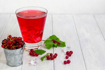Red currants on a light wooden background. Vitamin cocktail.