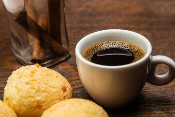 Café com pães de queijo e paus de canela.