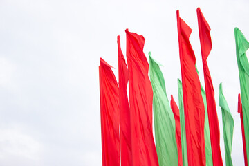 Red and green vertical flags waving in the wind. Green and red fabrics.