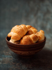 croissants in a ceramic bowl on a dark background vertical image
