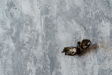metal door handles in the shape of hands folded in mudra, shot on a textured gray background, close-up, separate object, yoga theme, bronze shade, Indian motif