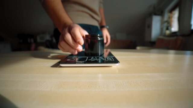 Man brings coffee cup on scale on the table.
