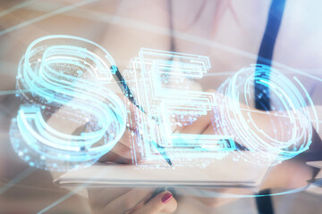 Double exposure of woman's hands making notes with SEO icon. Concept of Search engine optimization