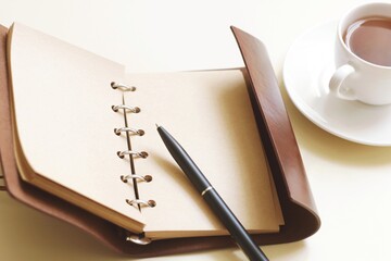 Brown diary, pen and cup of coffee. Office desk with stationery. Business concept stock photography