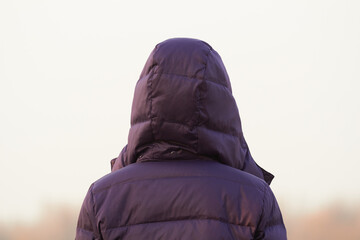 Unrecognizable woman in a jacket looking at the distance.
