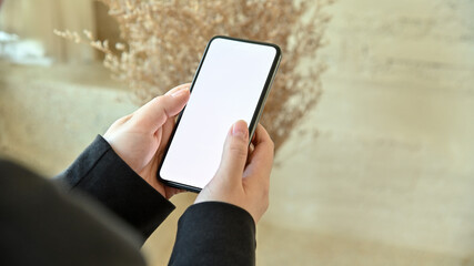 Close up image of male hands using smartphone blank screen mobile phones with blurred background. for graphic display.