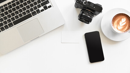 top view office table concept with camera, smartphone and laptop on white  table background with copy space.