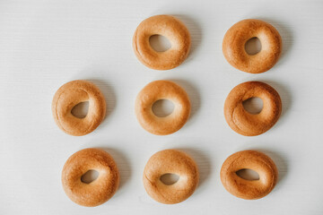 Drying or mini round bagels on a white wooden background. Top view. Copy, empty space for text