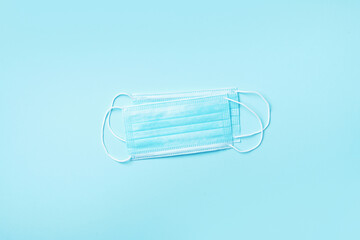 Surgical face mask on blue background with copy space. Minimal medical concept. Medical equipment. Products to stay safe during pandemic covid19 quarantine.