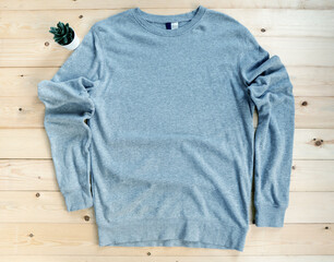 Gray male long sleeved shirt mock up flat lay on wooden background. Top front view