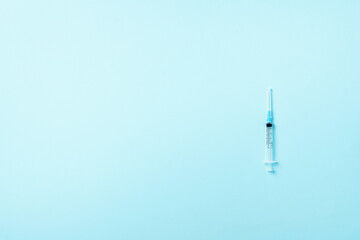 Syringe and needle on blue background. Injections and vaccination concept. Health protection equipment during quarantine Coronavirus pandemic
