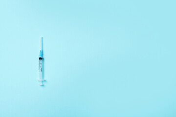 Syringe and needle on blue background. Injections and vaccination concept. Health protection equipment during quarantine Coronavirus pandemic