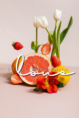 floral and fruit composition with tulips, red Alstroemeria, summer fruits near do all things with love lettering on beige