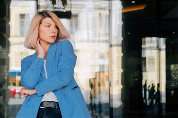 Portrait of a young girl with blond hair. Walking model through the sunny big city