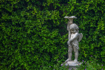 Ancient cupid statues and leaves background